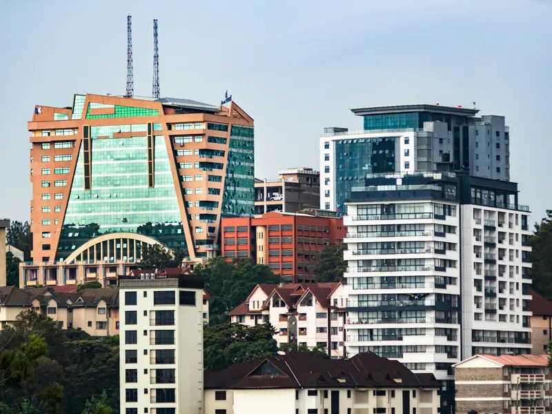 Modern skyline with glass office towers and apartment blocks under a pale sky