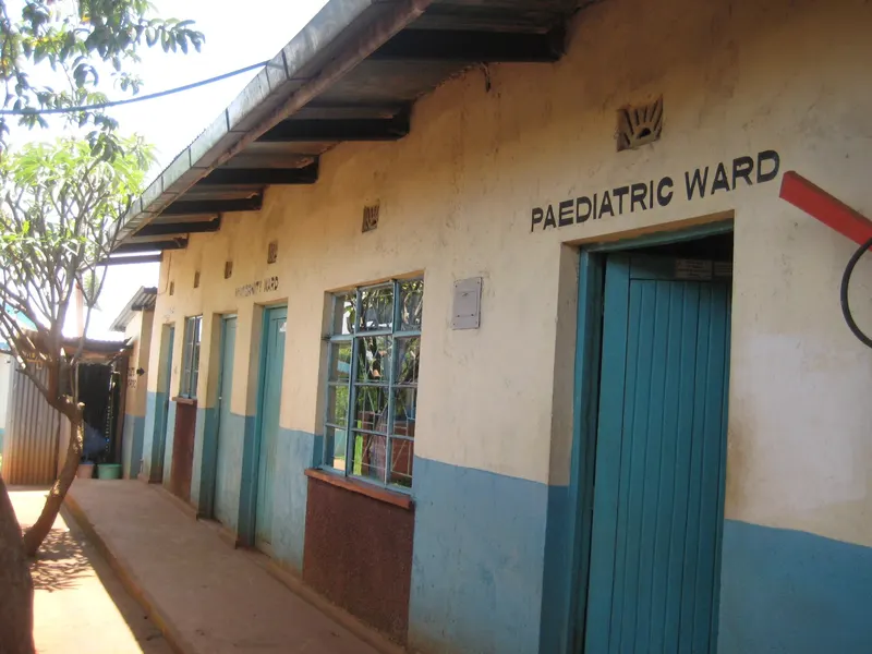 Exterior of a hospital ward block with blue doors and a sign reading Paediatric Ward