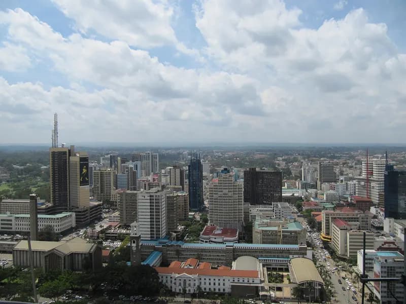 Aerial view of a dense city skyline with high-rise towers under cloudy sky